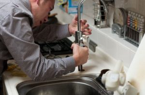 A plumber fixing a faucet