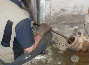 a plumber snaking a drain pipe